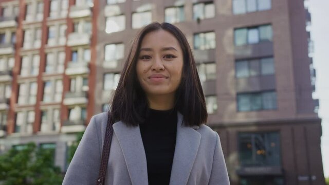 Portrait of a young smiling asian woman in the city steet