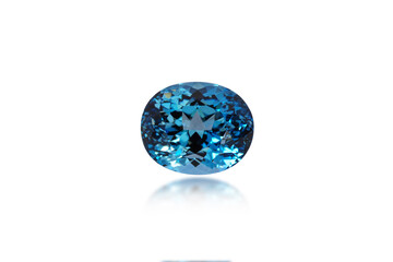 Natural London blue topaz oval shape gemstone. Heated, irradiated, color enhanced stone setting for making jewellery. Isolated on white background, blured semireflection. Gemology, mineralogy theme.