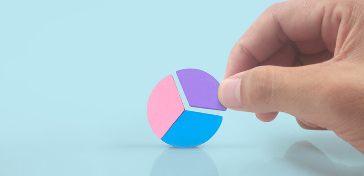 Business connecting piece of multi colored pie wood chart in hand