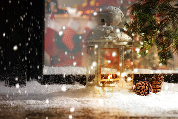 Snow falling onto window sill with Christmas lantern outdoors