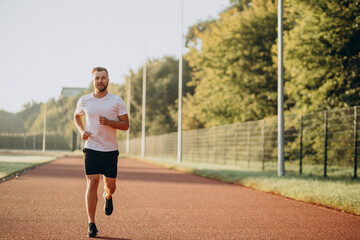 Obraz premium Man athlete jogging at stadium in the morning