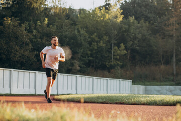 Man athlete jogging at stadium in the morning
