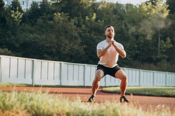 Man stretching before workout at the stadium