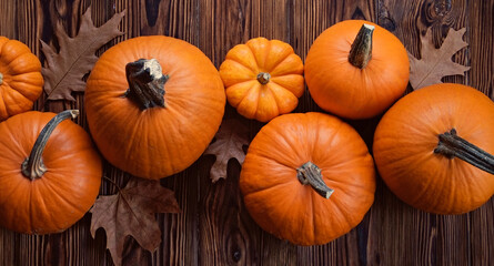 Thanksgiving background concept. Local produce pumpkin and autumn leaves with other decoration on wood textured table. Close up, copy space for text, top view, flat lay.