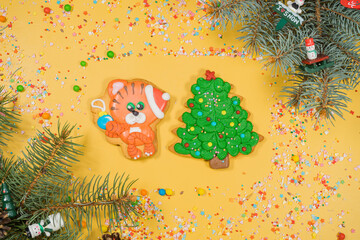 Christmas of gingerbread cookies in different shapes on yellow surface. Flat lay, top view.