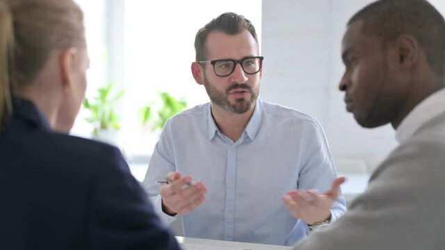 Businessman Scolding to Mixed Race Business People in Office
