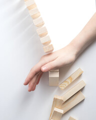 Close-up of fingers prevents the jenga wood block from falling