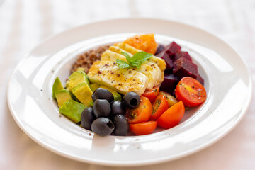 Healthy vegetables and grilled cheese salad on a plate, closeup