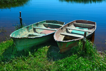 Naklejka na ściany i meble Two old boats on the shore, on a sunny summer day