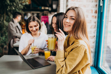 Three girls students preparing for exam with laptop in a cafe