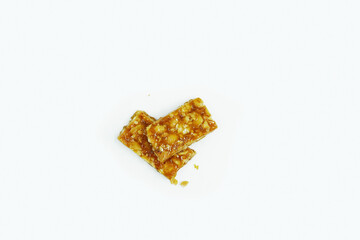 Roasted peanuts bar in a sweet molasses on a white background