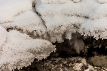 Icicles and frost on a snow-covered frozen river
