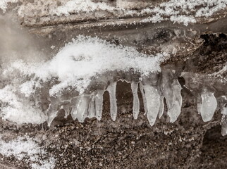 Icicles and frost on a snow-covered frozen river
