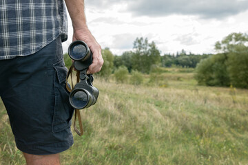Man on the trail holding binoculars