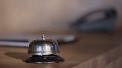 silver service bell on hotel reception counter.