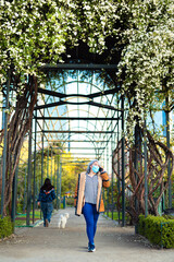 Portrait of a woman at the park with flowers at the background