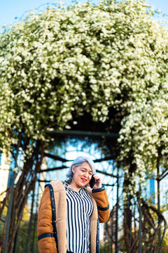 Portrait of a woman at the park with flowers at the background