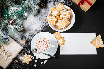 Christmas and New Year decoration composition. Top view of fur-tree branches on dark background with place for your text. Cups of fragrant coffee with gingerbread and chokolate.
