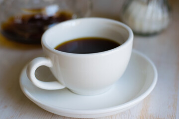 Fototapeta na wymiar Delicious americano coffee with sugar in a white cup in a coffee shop