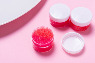 Lot of homemade lip scrub on pink background