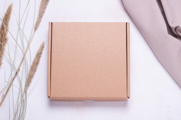 Brown cardboard box decorated with dried grass, mock up.
