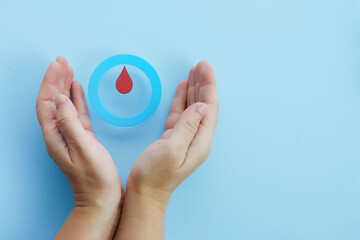 World diabetes day awareness. Woman hands with a blue circle with blood drop, symbol of the diabetes