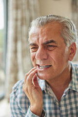 Mature Man At Home Suffering From Pain With Toothache