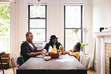 Lesbian parents with daughter at table in dining room