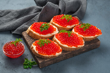Caviar sandwiches in close-up on a dark background.