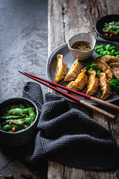 Gyozas with beans and sauce near spices and pea pods