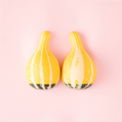 Breast cancer health and prevention concept. Flat lay two yellow-green zucchini on a pastel pink...