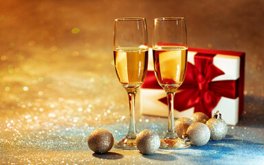 dwie lampki z szampanem i prezent zapakowany z czerwoną kokardę, impreza urodzinowa