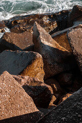 Strengthening the shore from erosion with concrete tetrapods. The seashore with concrete blocks. The element of water. Waves break on concrete.