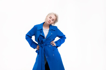 Blonde girl in a blue coat on a white background