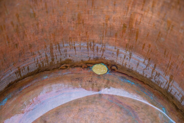 Copper background with rain traces. Copper cauldron with water. Soldering on a copper surface....