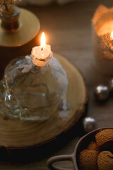Bowl of cinnamon cookies, lit candles and various Christmas decorations on the table. Selective focus.