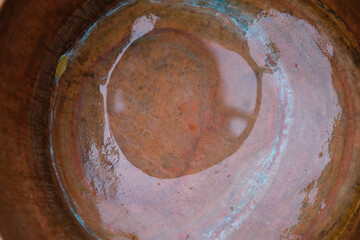 Water in a copper pot.Colorful circles on a copper surface. Patina. 