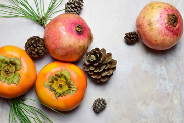 Fototapeta na wymiar Top view, autumn fruit, persimmon and pomegranate, on marble background.