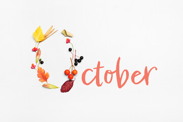Word OCTOBER with autumn leaves and berries on white background