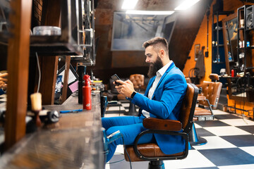 Young businessman in a suit at the barber shop
