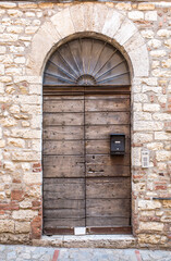 Vintage front door in the medieval city of Italy. Ancient streets of the city, beautiful doors and unusual door handles in the shape of a lion's head.