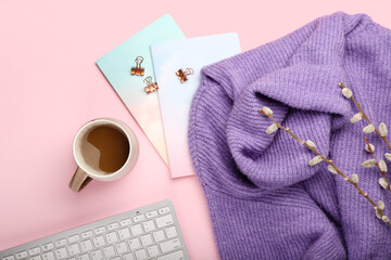Cup of coffee, sweater and notebooks on pink background