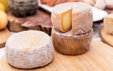 Wheels of crafted natural cheese at the market stall, wheels of hand crafted cheeses, several sorts of cheese are produced by farmers, food for breakfast and picnic