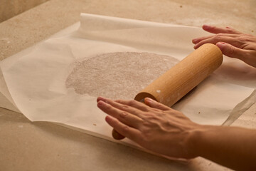 kneading with rolling pin the dough for gingerbread man preparation