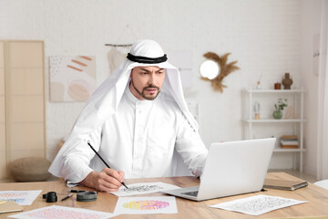 Male Arab calligraphist working in office