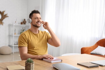 Man with headphones listening to audiobook at table