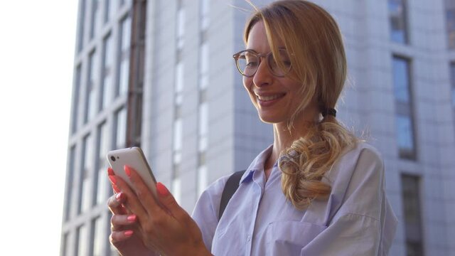 Beautiful woman smiling reading message with compliments on her mobilephone