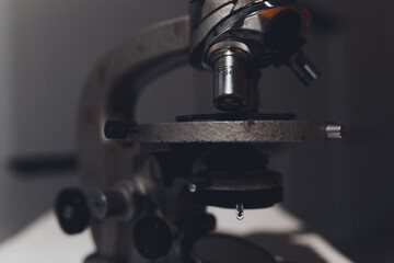 microscope for studying microbes and viruses against a gray three-dimensional wall. concept: photo wallpapers for scientific articles and publications about coronavirus and pandemic.