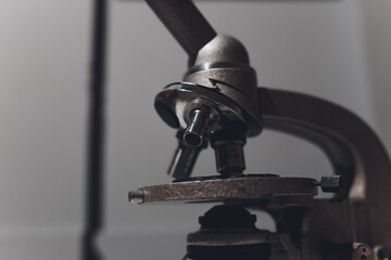 microscope for studying microbes and viruses against a gray three-dimensional wall. concept: photo wallpapers for scientific articles and publications about coronavirus and pandemic.