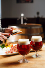 Woman's hands putting butter on bread to eat tartare with beer